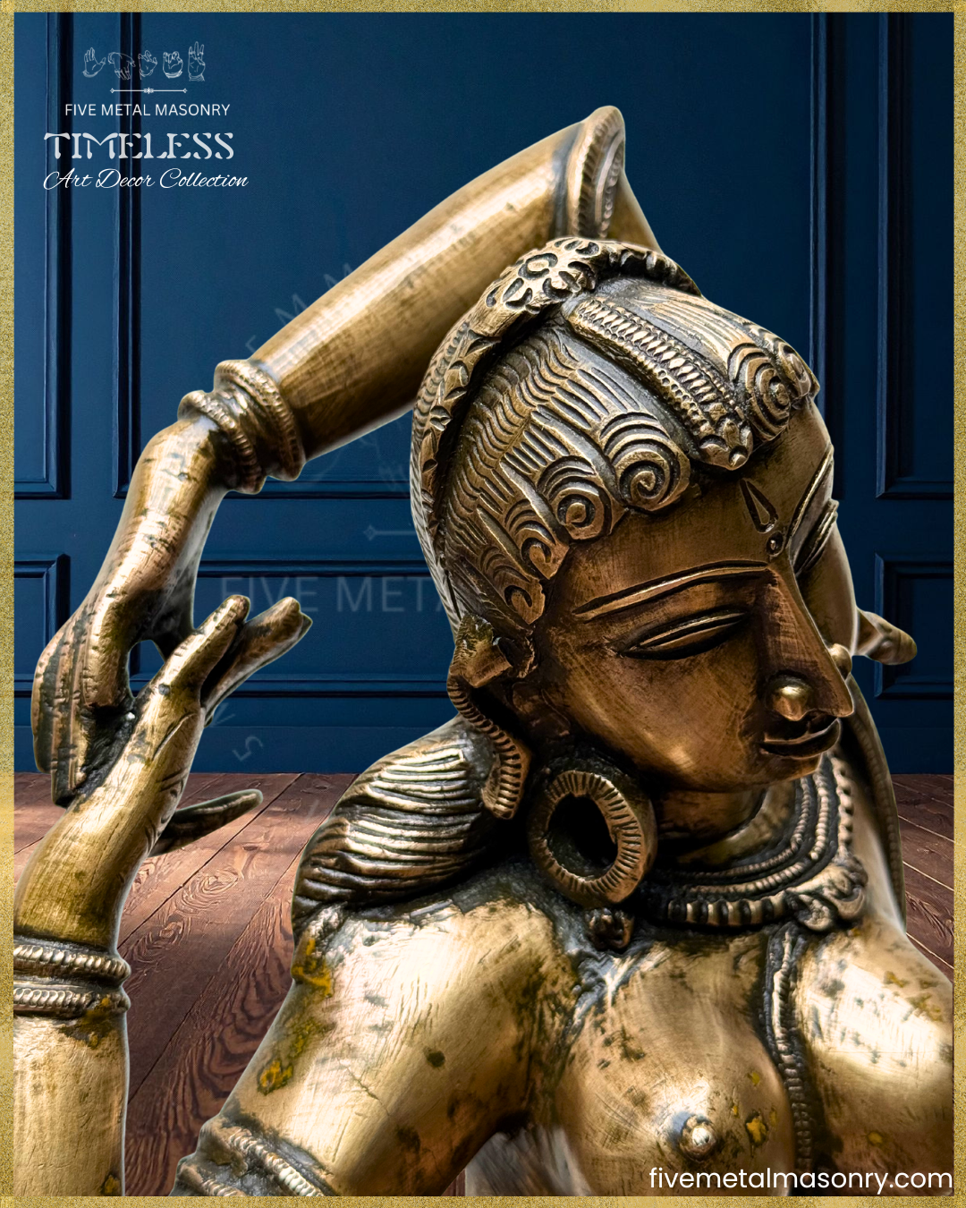 Close-up of a panchaloha bronze Apsara icon from the Timeless collection, highlighting the stylized coiffure, elongated eyes, circular ear ornaments, raised-arm pose, layered jewellery, and refined sculptural detailing rooted in South Indian iconographic tradition.