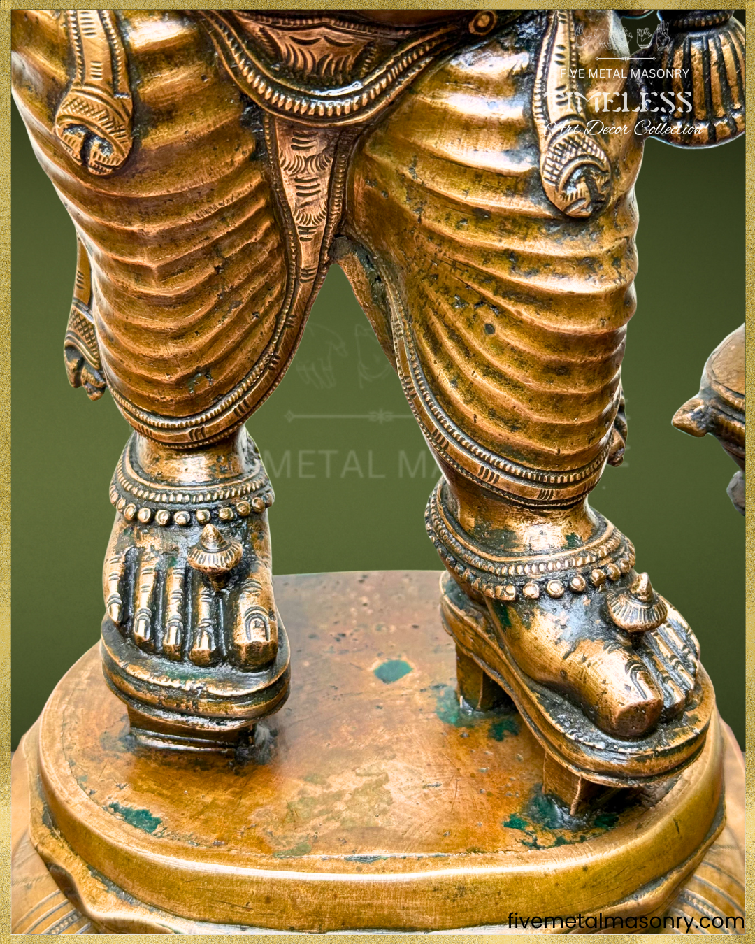 Close-up of antique finish Panchaloha bronze Ganesha highlighting detailed pleated drapery, anklets, paduka-style footwear, lotus pedestal and refined South Indian sculptural craftsmanship from the Timeless collection.